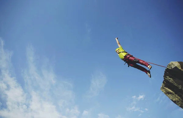 A man jumps into a canyon from a cliff. — Stock Photo, Image