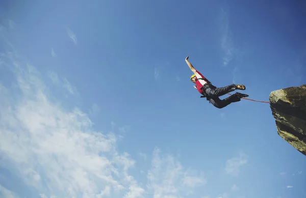 Ein Mann springt von einer Klippe in eine Schlucht. — Stockfoto