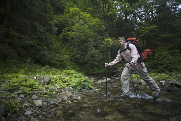 Caminata de verano en las montañas con una mochila y tienda de campaña . — Foto de Stock