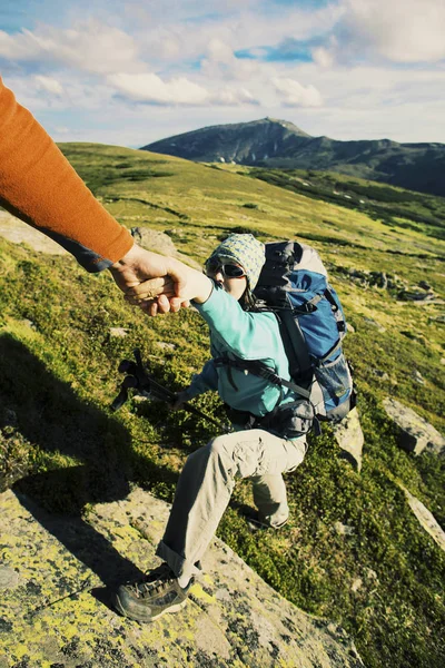 Pareja Hombre y Mujer ayudan a dar las manos escalando montañas rocosas — Foto de Stock