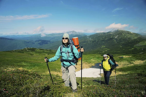 男と女のバックパック旅行スポーツ李と山脈のハイキング — ストック写真