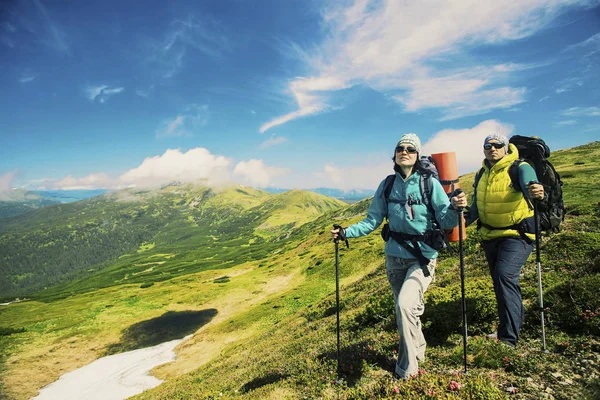 Muž a žena, Turistika v horách s batohem cestovní sportovní li — Stock fotografie