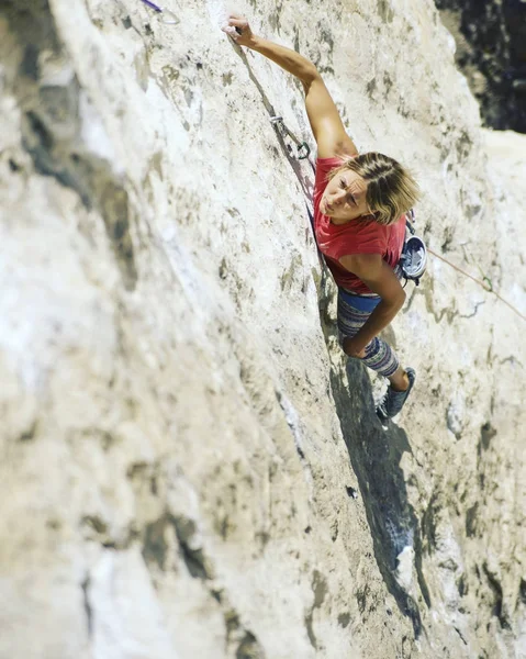 Mujer escaladora de rocas. Escalador de rocas sube a una pared rocosa. Mujer m — Foto de Stock
