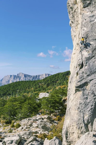 Ο άνθρωπος ροκ ορειβάτης. Ροκ ορειβάτης ανεβαίνει σε έναν βραχώδη τοίχο. Ο άνθρωπος κάνει — Φωτογραφία Αρχείου