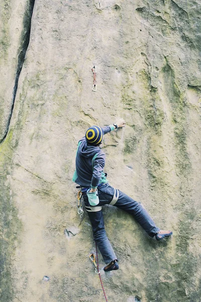 Um homem sobe a rocha em uma rota de escalada . — Fotografia de Stock