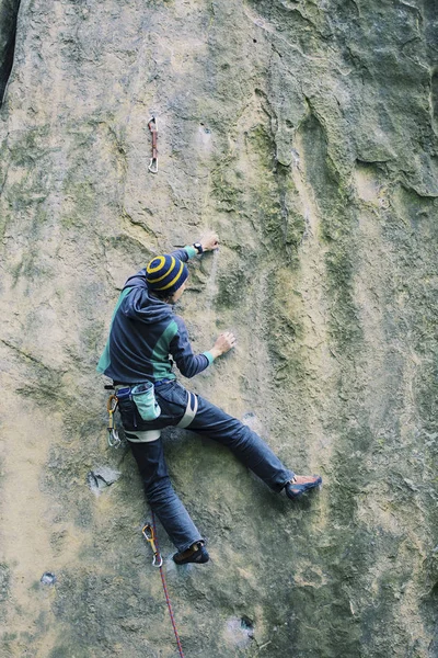 Um homem sobe a rocha em uma rota de escalada . — Fotografia de Stock