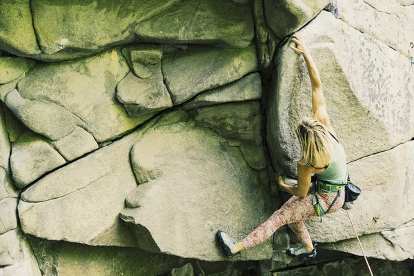 A menina sobe a rocha em uma rota de escalada . — Fotografia de Stock