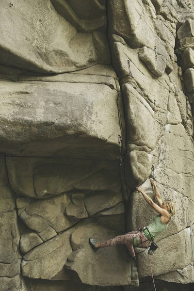 A menina sobe a rocha em uma rota de escalada . — Fotografia de Stock