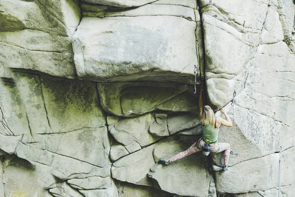 Het meisje klimt de rots op een klimroute. — Stockfoto