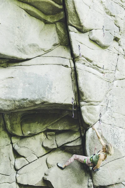 A menina sobe a rocha em uma rota de escalada . — Fotografia de Stock