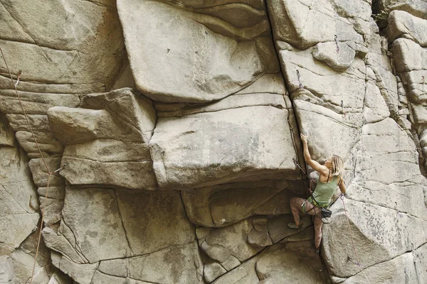 A menina sobe a rocha em uma rota de escalada . — Fotografia de Stock