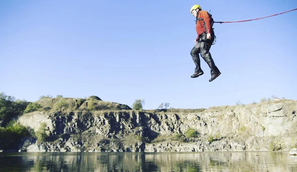 Springen van een rots in een canyon met een touw. — Stockfoto