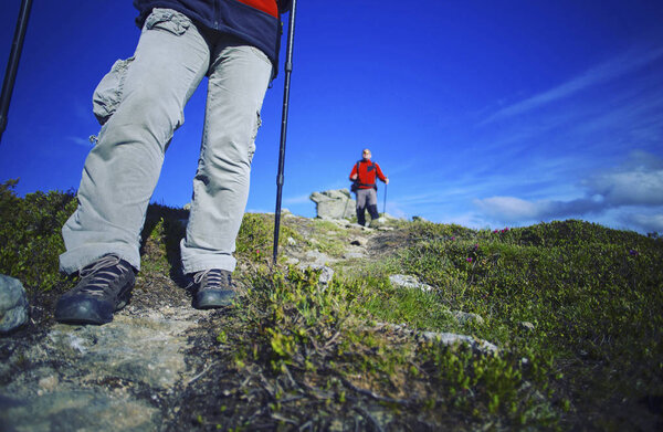 Summer hike in the mountains with a backpack and tent.