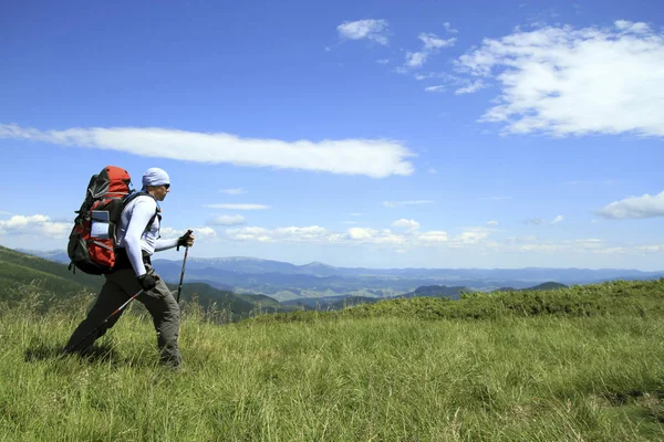 Zomer wandeling in de bergen met een rugzak en tent. — Stockfoto