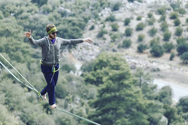 Een man loopt langs een uitgerekte slinger. Highline in de mounta — Stockfoto