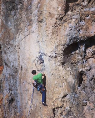 Güçlü bir adam, doğal bir arazide zorlu bir tırmanış rotasının üstesinden gelir. Türk kayalıklarında dağcı trenleri. Aktif yaşam tarzı. Aşırı hobi..