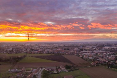 Küçük bir şehrin üzerinde gün batımı bir dağın arka planında İHA 'nın görüntüsü