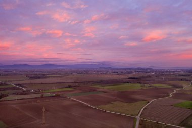 Küçük bir şehrin üzerinde gün batımı bir dağın arka planında İHA 'nın görüntüsü