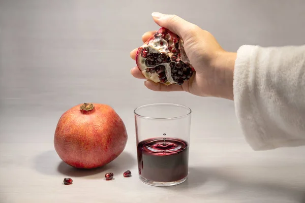 Kadın eli nar suyu sıkar.