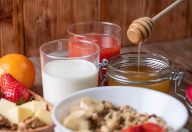 Süt, müsli, bal ve çilekli sağlıklı kahvaltı. 