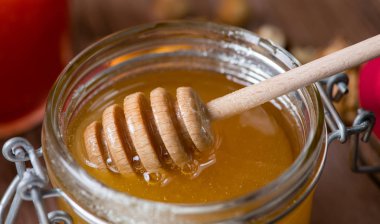 Kavanoz bal ve ahşap arka plan üzerinde Kepçe