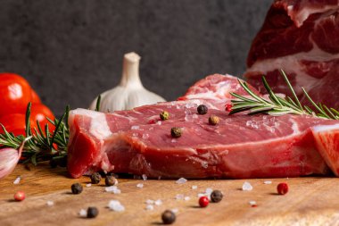 Koyu çimento arka planında kesilmiş çiğ et ve sebzeler