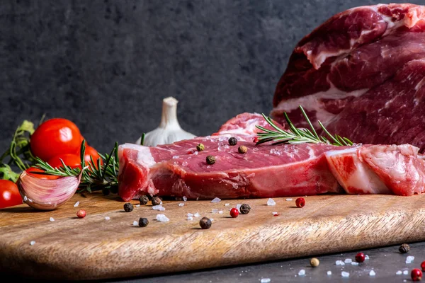 Koyu çimento arka planında kesilmiş çiğ et ve sebzeler