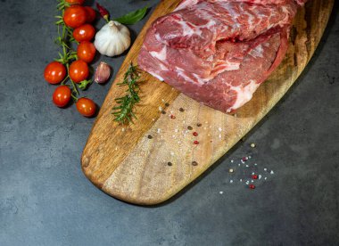 Koyu çimento arka planında kesilmiş çiğ et ve sebzeler