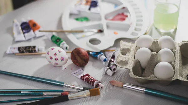 Çocuklar Paskalya yumurtalarını resim malzemeleriyle boyarlar. Anne ve bebek paskalya yumurtalarını boyar.. 