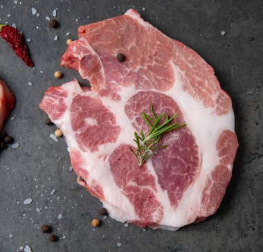 Biberiye ve karabiberli gri çimento arka planda bir parça et