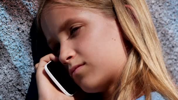 Niño hablando en el teléfono inteligente, Niño usando el teléfono inteligente, Chica jugando al aire libre en el parque — Vídeos de Stock