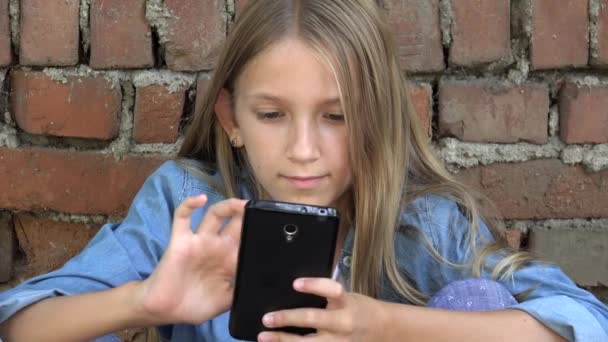 Kid using Smartphone, Child Playing on Smart Phone, Girl Outdoor in Park — Stock Video