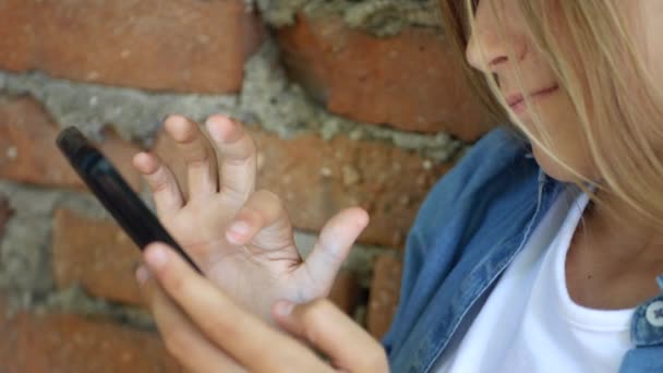 Niño usando Smartphone, Niño jugando en el teléfono inteligente, Chica al aire libre en el parque — Vídeo de stock