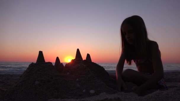 Dziecko budynku zamku na plaży o zachodzie słońca, dzieciak bawiący się Piaski nad morzem, morze dziewczyna — Wideo stockowe