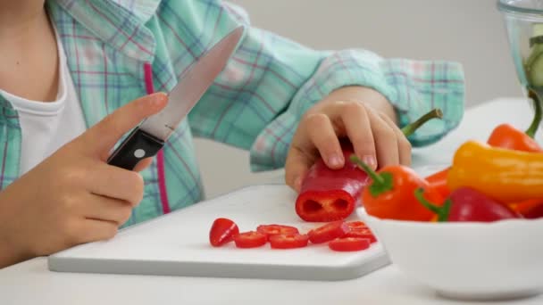 Ребенок готовит зеленый салат на кухне, ребенок режет овощи девушка здоровая пища — стоковое видео