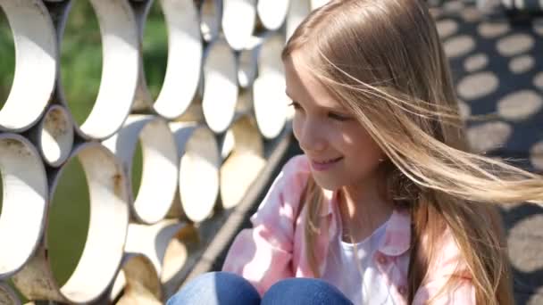 Задумлива дитина в парку, яскрава маленька дівчинка на відкритому повітрі, нудно експресивне дитяче обличчя — стокове відео