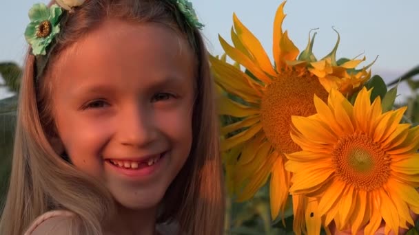4K niño jugando en el campo de girasol, niña cara retrato riendo, niño sonriente en la agricultura — Vídeos de Stock