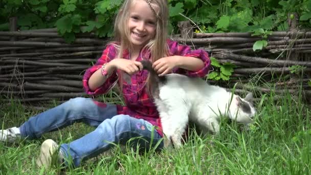 Хлопчик грається з котом, дитина пече свою Пет, щасливу усміхнену дівчину з кошеням в садку трави — стокове відео