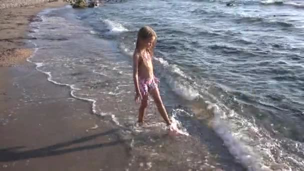 4K Niño jugando en la playa, Niño corriendo en la orilla del mar, Niña caminando olas del mar en la costa — Vídeo de stock