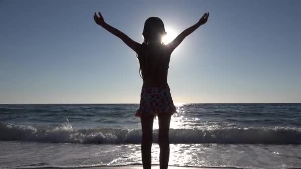 4K Kid Jouer sur la plage dans les rayons de soleil, Silhouette fille dans la côte de rayon de soleil, Vue d'été sur la mer — Video