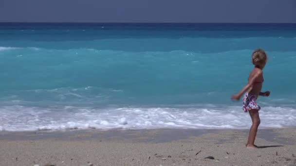 4K niño corriendo en playa costa arena huella de niña pequeña mar olas — Vídeo de stock