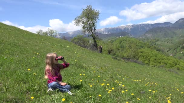 4K-Kinderfernglas, Spyglass in den Bergen, Touristenkind auf dem Campingplatz, Mädchen spielen draußen auf der Wiese in der Natur — Stockvideo