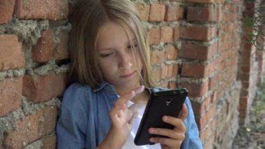 Akıllı telefon kullanan çocuk, Akıllı Telefon 'da oynayan çocuk, Park' ta gezen kız.