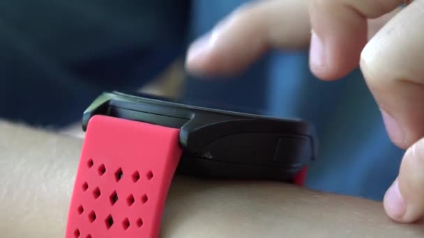 स्मार्ट वॉच, पार्कमध्ये स्मार्टवॉच आउटडोअर वापरणे किड, बाल स्मार्टफोनवर खेळत आहे — स्टॉक व्हिडिओ