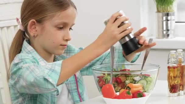 Ребенок ест зеленый салат, ребенок на кухне, девочка-повар-подросток ест свежие овощи, приготовление здоровой зеленой пищи — стоковое видео