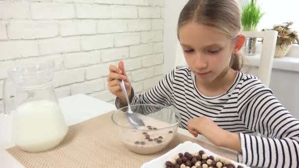 Παιδί που τρώει γάλα και δημητριακά στο πρωινό, παιδί στην κουζίνα, έφηβος κορίτσι που δοκιμάζει υγιεινά τρόφιμα στο γεύμα, διατροφή — Αρχείο Βίντεο