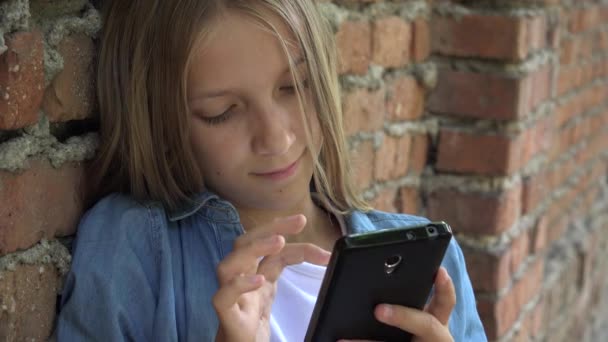 스마트폰을 사용하는 아이, 스마트 폰으로 채팅하는 아이, 공원에서 인터넷 검색하는 십 대 소녀 — 비디오