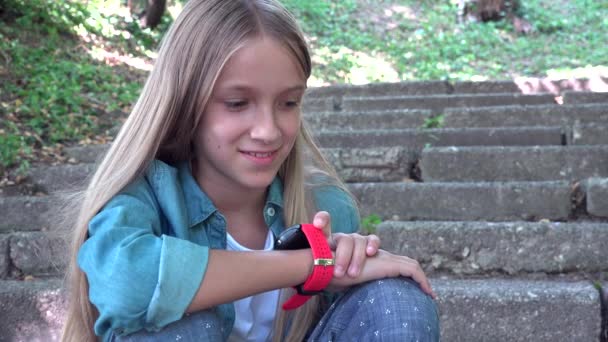 Smart Watch, dítě s použitím SmartWatch venku v parku, dětský rozhovor u telefonu Smartphone — Stock video