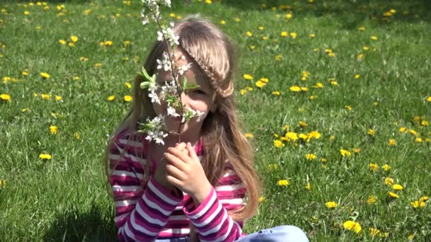 4K小孩闻春花 小孩在外面的草地上玩耍 小女孩笑 — 图库视频影像