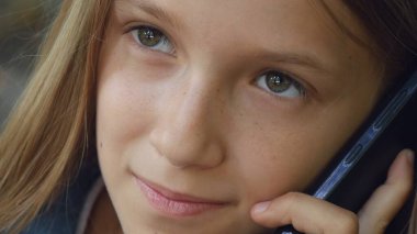 Akıllı telefondan konuşan çocuk, akıllı telefon kullanan çocuk, parkta oynayan ergen kız.